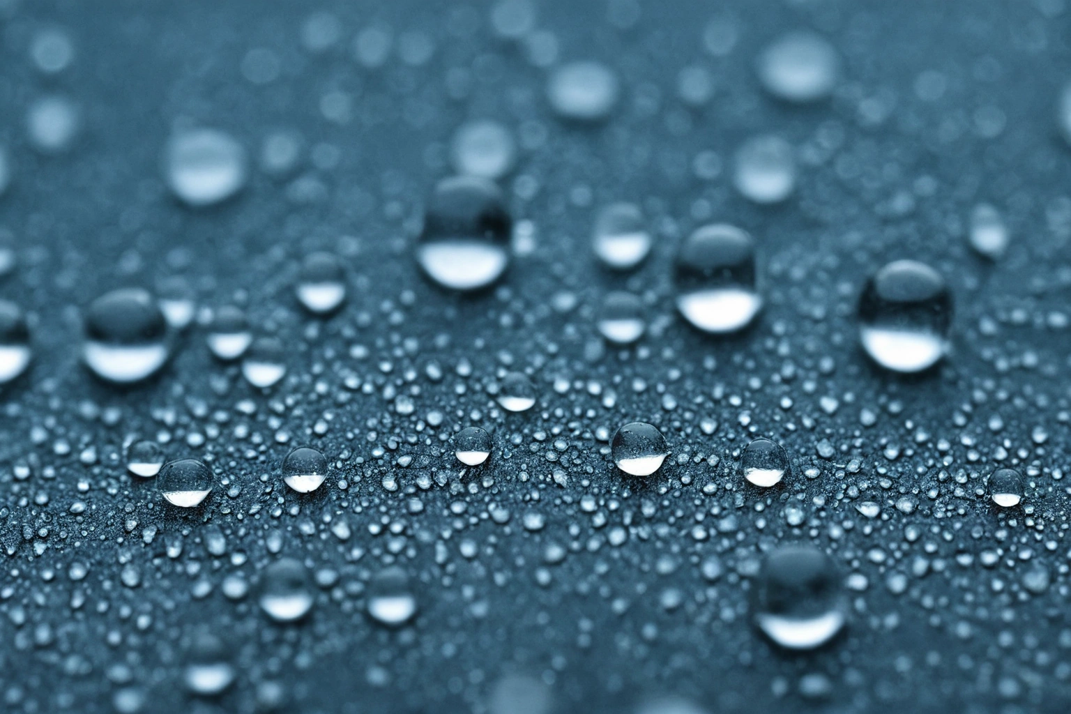 Macro photograph of water droplets beading on the surface of a woven upholstery fabric
